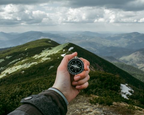 person holding silver compass