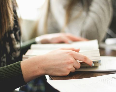 woman sitting on chair in front of table white reading book