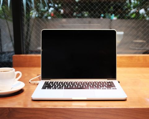 laptop computer beside coffee mug