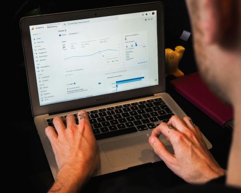 person using macbook pro on black table