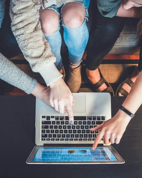 three person pointing the silver laptop computer