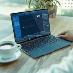person using black laptop computer on brown wooden table
