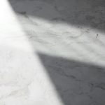 a white marble counter top with a long shadow