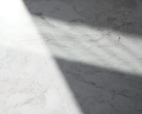 a white marble counter top with a long shadow