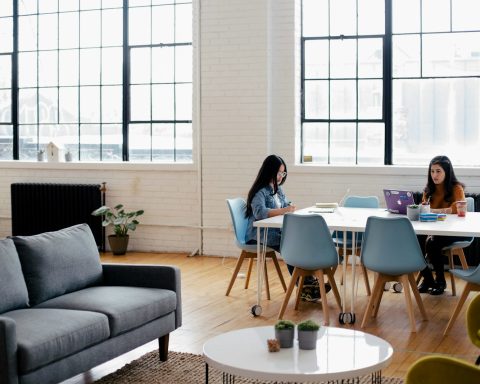 two women sitting in front of white table