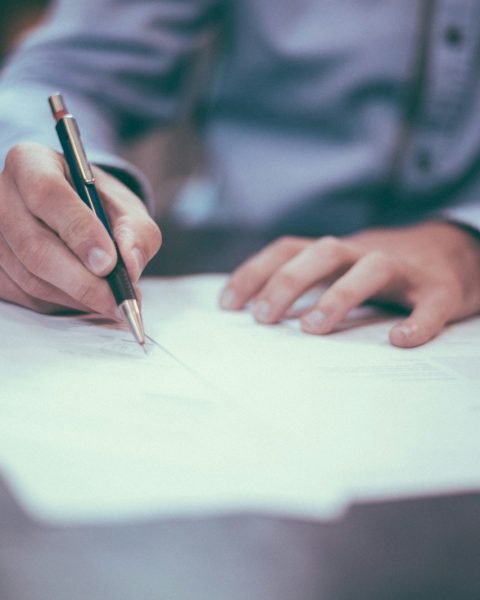 man writing on paper