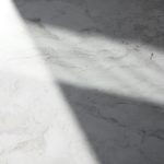 a white marble counter top with a long shadow