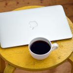 Ondernemer werkt achter laptop aan tafel thuis tijdens opstartfase van bedrijf