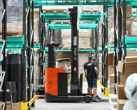 A man standing in a warehouse with a fork lift